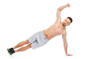 Athletic attractive man doing fitness exercises on the white photo