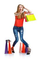 Happy lovely woman with shopping bags and credit card over white photo