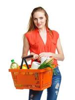 Happy woman holding a basket full of healthy food. Shopping photo