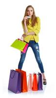 Happy lovely woman with shopping bags and credit card over white photo