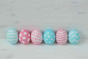 Pink and blue eggs on a wooden background photo