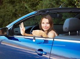 Smiling caucasian woman showing key in a cabriolet photo