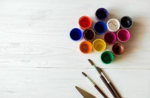 Painting set with brushes, paints, watercolor, acrylic paint on a white wooden background top down view photo