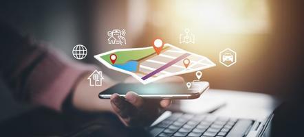 mano sostener inteligente teléfono y toque virtual mundo y modelo mapa con ubicación punto , GPS aplicación, icono viaje mapas y encontrar lugares en el en línea sistema, todas pantalla gráficos son generado,buscando para viajar. foto