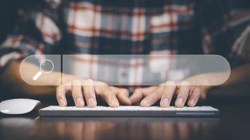 búsqueda de información de datos de Internet con barra de búsqueda en blanco. las manos del hombre están usando un teclado de computadora para buscar información. usando la consola de búsqueda con su sitio web. foto