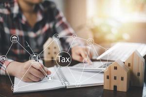 Concept of tax payment optimisation business finance,Man using calculator and taxes icon on technology screen,income tax and property, background for business, individuals and corporations such as VAT photo