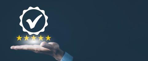 Quality assurance of business services, Businessman Hand shows the sign of the top service Quality assurance in Black background , Guarantee, Standards, ISO certification and standardization concept. photo