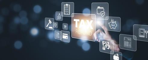 Hand touch with bar TAX REFUND and refund tax of duty taxation business, graphs and chart being demonstrated on the screen media,  tablet pc and selecting tax refund. photo