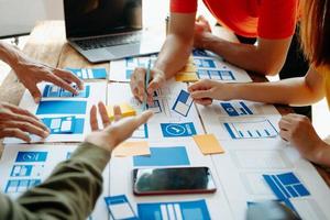 UX developer and ui designer brainstorming about mobile app interface wireframe design with customer breif and color code at modern office. photo