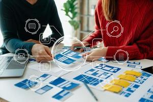 Close up view of UI developer team brainstorming on their project with laptop, smartphone and digital tablet. Creative digital development agency. photo