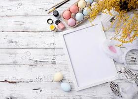 Pastel colored Easter eggs with blank white frame for mockup design photo