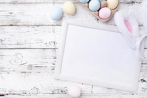 Pastel colored Easter eggs with blank white frame for mockup design photo