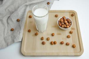 on a wooden board hazelnut nuts and a glass of milk, the concept of milk from nuts photo