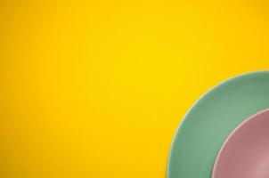 colorful plates composition on yellow background photo