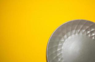 Gray plate for food on yellow background. Trending colors of 2021. Creative copy space photo