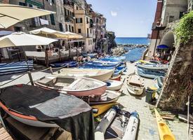 Ligurian town of Manarola with tourists and moored boats photo