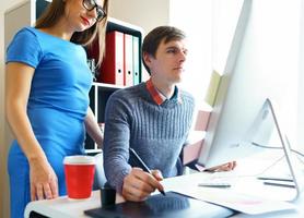 Beautiful young woman and man working from home office photo