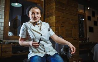 Fashion woman barber hairstylist with straight razor in hand in the barbershop photo