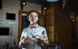 Fashion woman barber hairstylist with scissors in hand in the barbershop photo