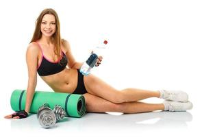 Beautiful sport woman with dumbbells, bottle of water and mat for fitness photo