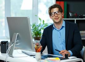 Handsome young man working from home office photo