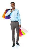 Happy african american man holding shopping bags on white background photo