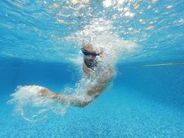 barba hombre con lentes nadando debajo agua en el piscina foto