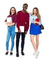 Three happy students standing and smiling with books photo