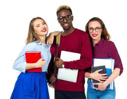 Three happy students standing and smiling with books photo