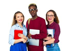 Tres contento estudiantes en pie y sonriente con libros foto