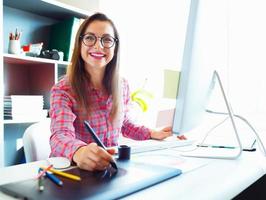 Graphic designer drawing something on graphic tablet at the work place photo