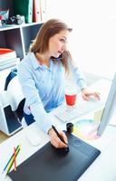 Beautiful business woman doing several things at once at the home office photo