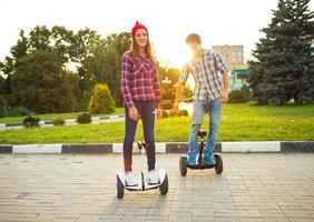 joven Pareja montando hoverboard - eléctrico scooter, personal eco transporte, giroscopio scooter, inteligente equilibrar rueda foto