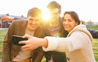 sonriente amigos haciendo selfie al aire libre foto