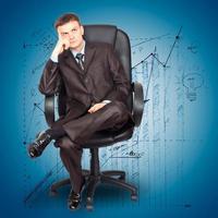 Businessman sitting on chair against graph background photo