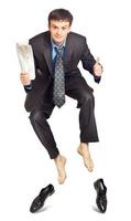 Businessman jumping with newspaper in hand photo