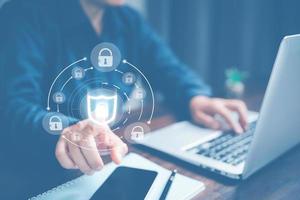 Cybersecurity and privacy concepts to protect data. Lock icon and internet network security technology. Businesswoman protecting personal data on laptop computer with virtual screen interfaces. photo
