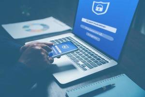 Cybersecurity and privacy concepts to protect data. Lock icon and internet network security technology. Businesswoman protecting personal data on samart phone and laptop computer with virtual screen. photo