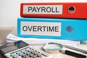 Payroll Overtime. Binder data finance report business with graph analysis in office.