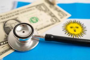 Black stethoscope with US dollar banknotes on Argentina flag background, Business and finance concept. photo