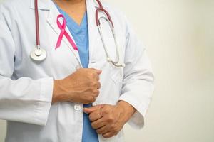 cáncer de mama, doctora asiática con cinta rosa, símbolo del día mundial del cáncer de mama. foto