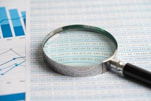 Magnifying glass on graph paper. Financial development, Banking Account, Statistics, Investment Analytic research data economy, Business concept. photo
