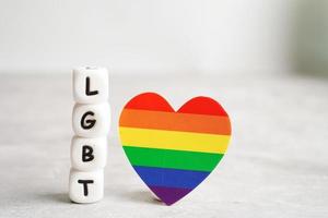 carácter de texto lgbt con el corazón de la bandera del arco iris como símbolo del mes del orgullo lesbiana, gay, bisexual, transgénero, derechos humanos, tolerancia y paz. foto