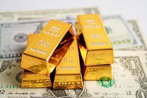 Gold bars on US dollar banknote money, finance trading investment business currency concept. photo