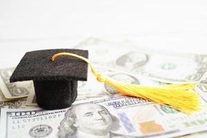 sombrero de la brecha de graduación en el dinero de los billetes en dólares estadounidenses, concepto de enseñanza de aprendizaje de la tarifa de estudio de educación. foto