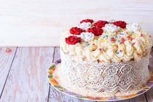 blanco pastel con crema y rojo rosas en blanco plato foto