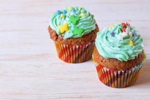 Colorful cupcakes on a white wooden background photo
