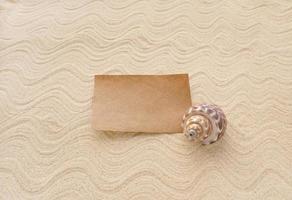 A business card and a shell on the sand. The concept of zen, beach holidays, the sea and travel photo