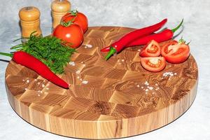 Wooden board for cutting handmade products with chopped vegetables. On a light background. photo