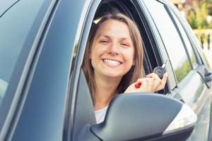 sonriente joven dama sentado en un coche foto